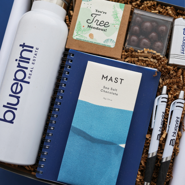 branded real estate gift with branded water bottle and pens in a blue gift box