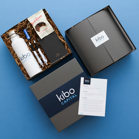 three gift boxes with custom branded packaging with blue and black products