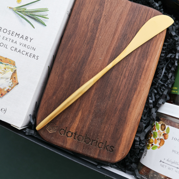 branded cutting board with gold cheese knife in gift box